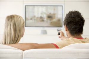 Couple in living room watching television